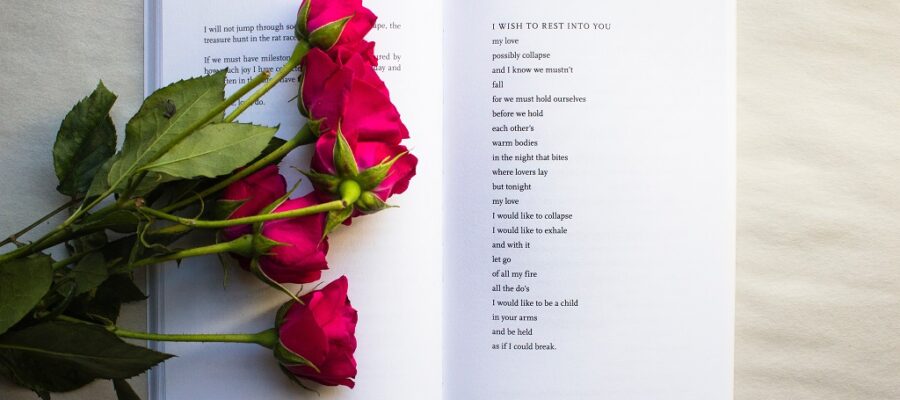 Funeral poetry book with red flowers laid on top